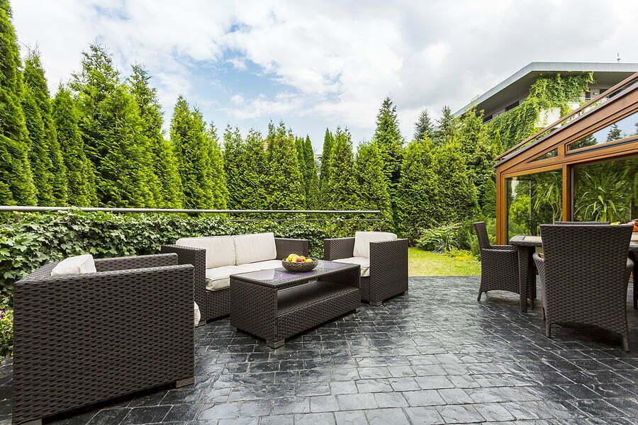 Large Terrace Patio With Garden Furniture large terrace patio with rattan garden furniture set surrounded by lush greenery